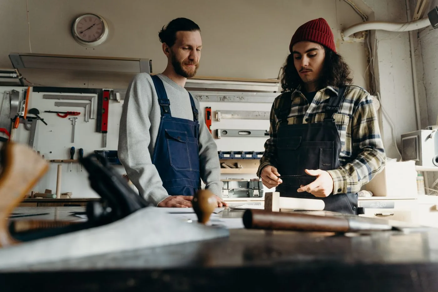 Two carpenters working together at a workshop bench