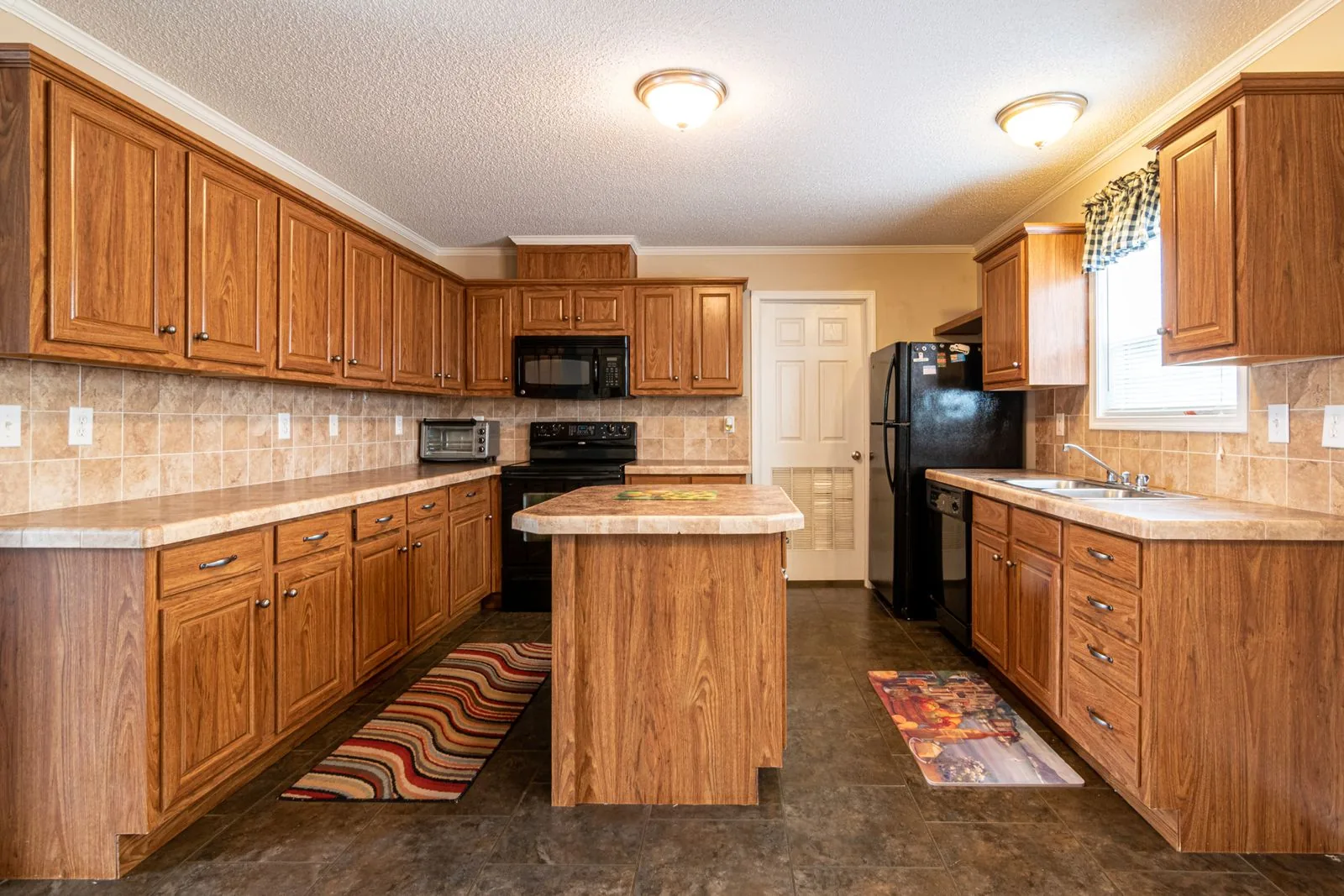 A kitchen of wooden cabinets and a marble countertop — cabinet refacing cost in Murfreesboro, TN