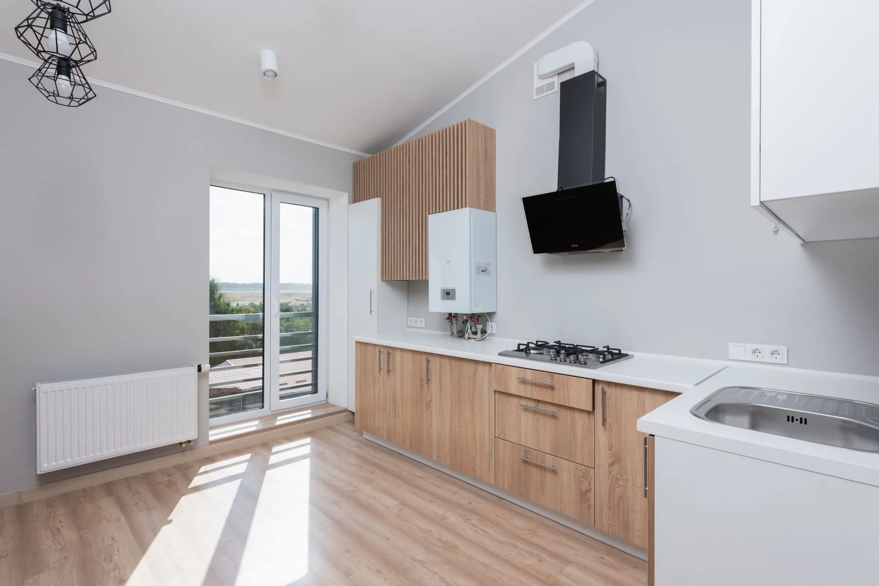 A kitchen of wooden cabinets beside tall windows — cabinets in Murfreesboro, TN