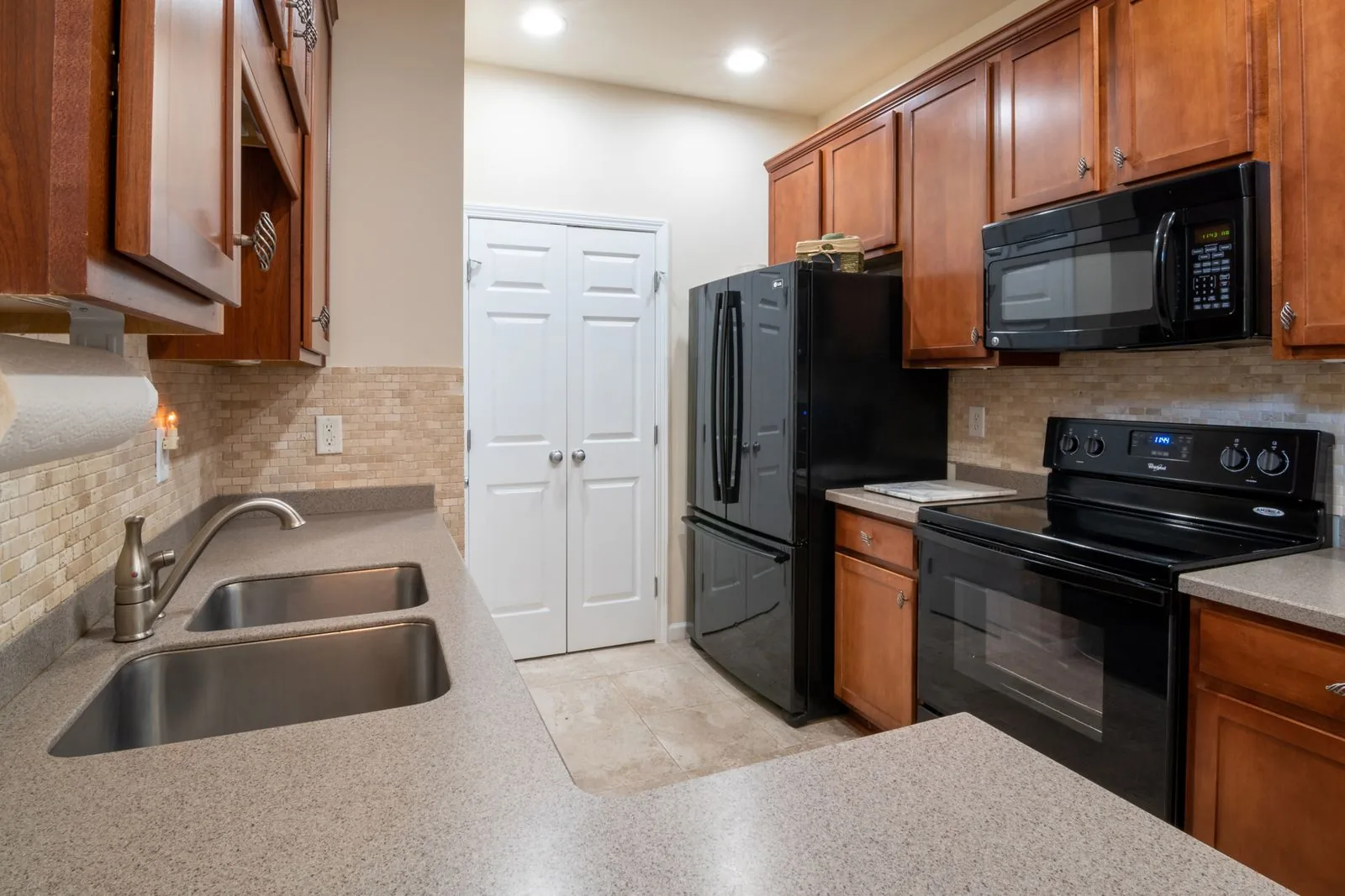 A kitchen of wooden cabinets under a marble countertop — cabinet refinishing in Murfreesboro, TN