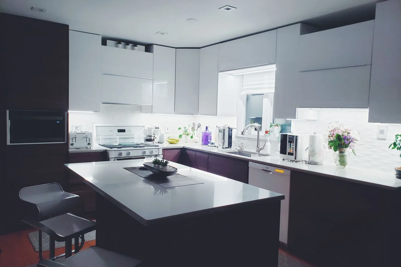 A kitchen laid out around an island with full-height white cabinets
